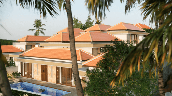Aerial view of a luxury Balinese villa with multiple terracotta roofs and a swimming pool, framed by palm fronds.