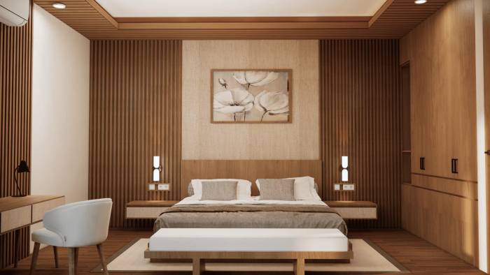A modern bedroom with a large bed, warm wooden paneling, subtle lighting, and a small desk area.