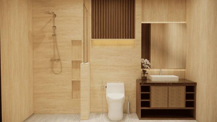 A modern luxury bathroom featuring travertine walls, a rainfall shower, toilet, and a vanity with rattan detailing and orchid decor.