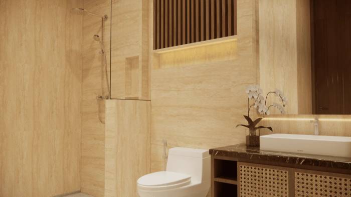 Elegant bathroom with travertine walls, modern shower, white toilet, vanity with vessel sink, and an orchid plant.