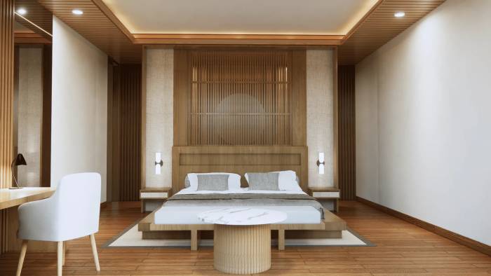 Spacious bedroom with a king bed, wooden headboard, light decor, a desk, and a modern marble coffee table.