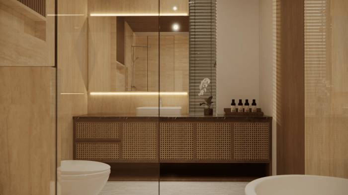 A luxurious bathroom with a rattan vanity cabinet, white vessel sink, back-lit mirror, and orchid decor.