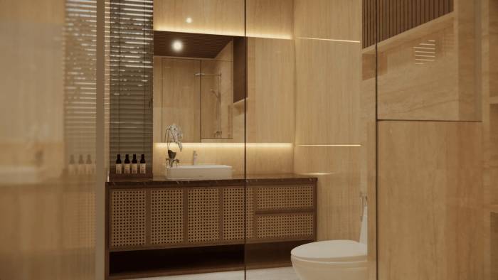 A modern and luxurious bathroom with warm lighting, a vanity with a white sink, rattan cabinetry, and a toilet.