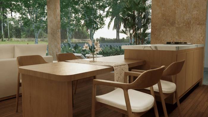 Modern open-plan living and dining area with wooden table, chairs, a white sofa, and a kitchen island, overlooking tropical greenery.
